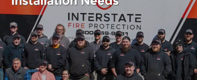 A team of Interstate Fire Protection employees standing and sitting in front of a branded company truck, symbolizing their commitment to fire suppression installation services. The title reads, "Why Choose Interstate Fire Protection for Your Fire Suppression Installation Needs," with the Interstate Fire Protection logo in the bottom right corner.