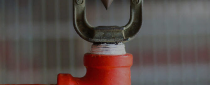 A close-up view of a fire sprinkler head, representing deluge systems used for fire protection. The text reads, "Understanding Deluge Systems: Definition, Applications, and Benefits for Fire Protection," with the Interstate Fire Protection logo at the top right.